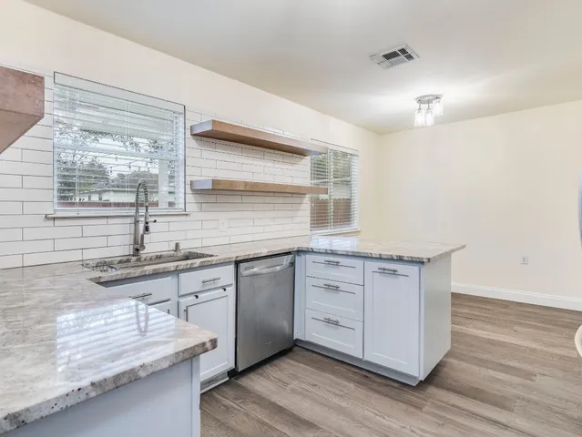 a kitchen with granite countertop a sink and a stove