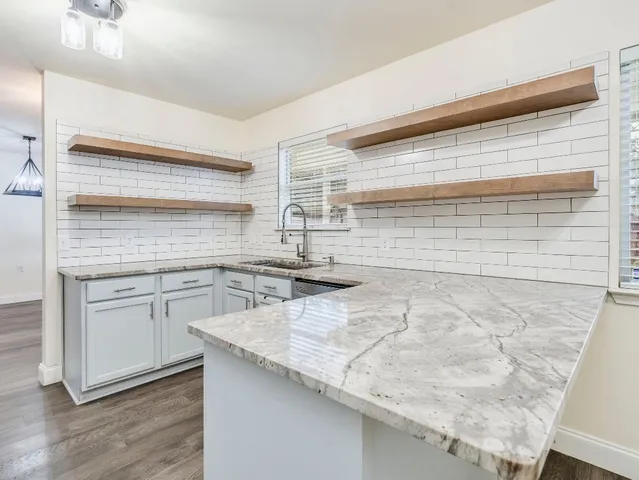 a kitchen with granite countertop white cabinets and white appliances