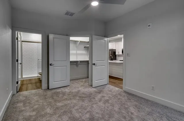 an empty room with closet and windows