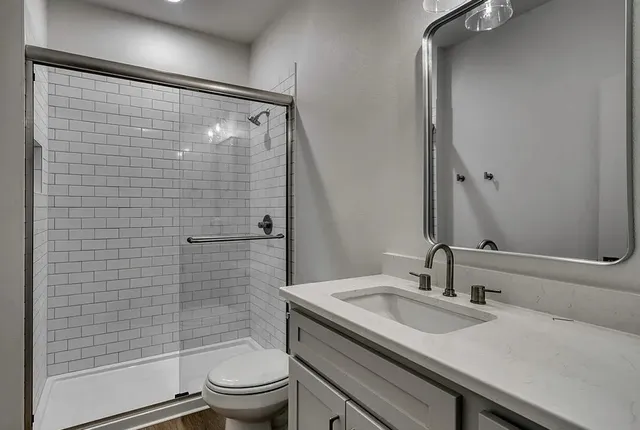 a bathroom with a sink a toilet and shower