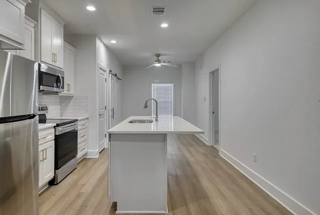 a kitchen with a sink appliances and cabinets