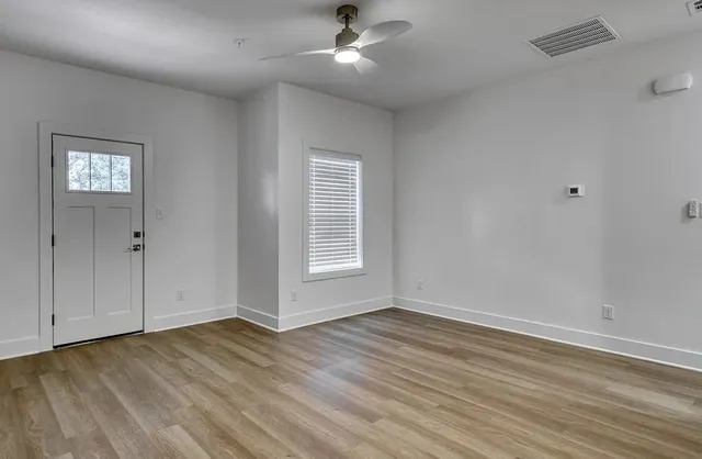 wooden floor in an empty room with a window