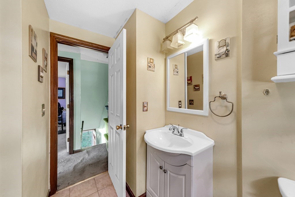40 Prospect Street, Unit 1B Westfield, MA 01085 - Photo 13 of 24 a bathroom with a sink a mirror a toilet and a shower