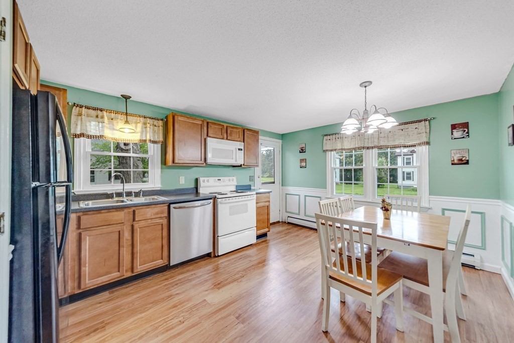 40 Prospect Street, Unit 1B Westfield, MA 01085 - Photo 3 of 24 a open dining room with stainless steel appliances granite countertop furniture a chandelier and wooden floor