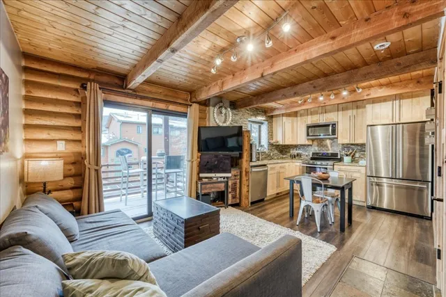 a living room with furniture a flat screen tv and kitchen view