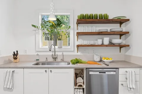 a kitchen with a sink a counter cabinets and a window