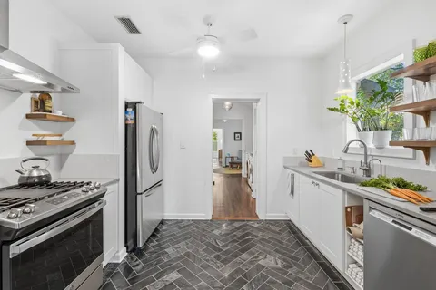 a kitchen with stainless steel appliances a stove a sink and a refrigerator