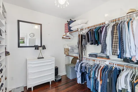 a view of walk in closet with clothes and shoes
