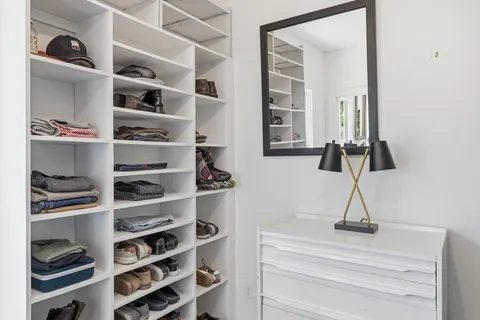 a view of walk in closet with clothes and shoes