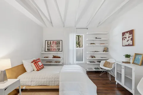 a bedroom with furniture and a book shelf