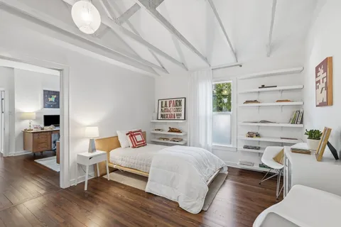 a bedroom with a bed and wooden floor