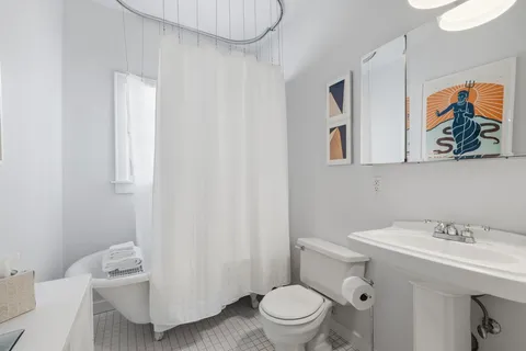 a bathroom with a sink a toilet and shower curtain