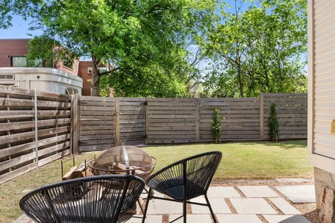 a view of a patio with table and chairs with wooden fence and plants
