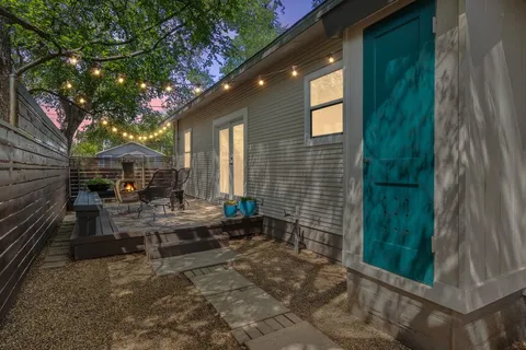 a backyard of a house with fountain table and chairs