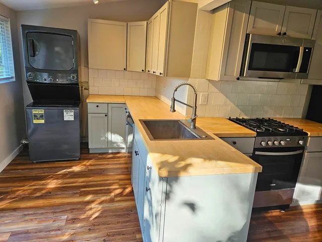a kitchen with a sink a stove and cabinets