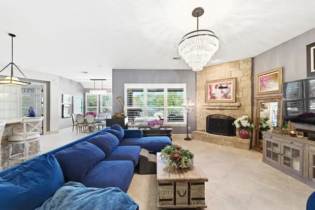 a living room with furniture a fireplace and a large window
