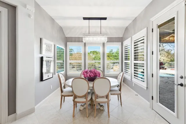 a dining room with furniture a chandelier and wooden floor