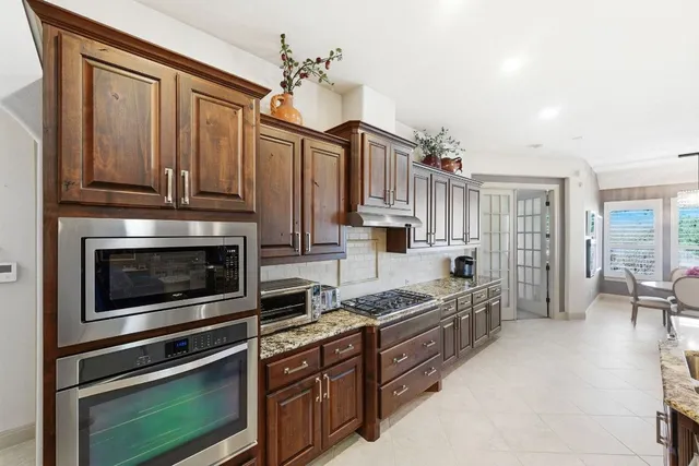 a kitchen with stainless steel appliances granite countertop a stove a sink and a refrigerator