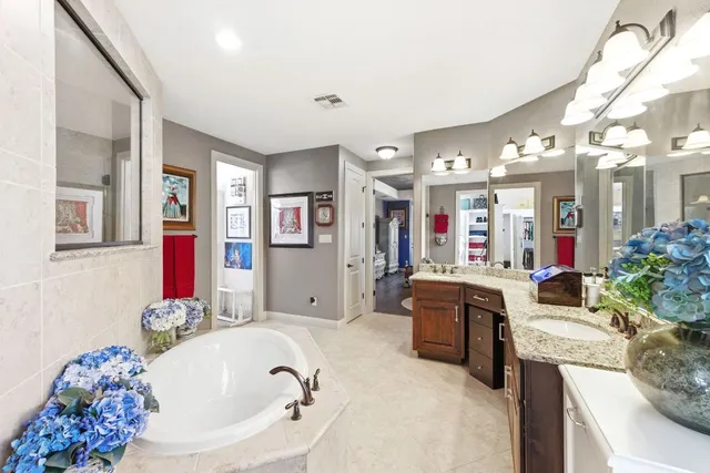 a large bathroom with a tub sink and mirror