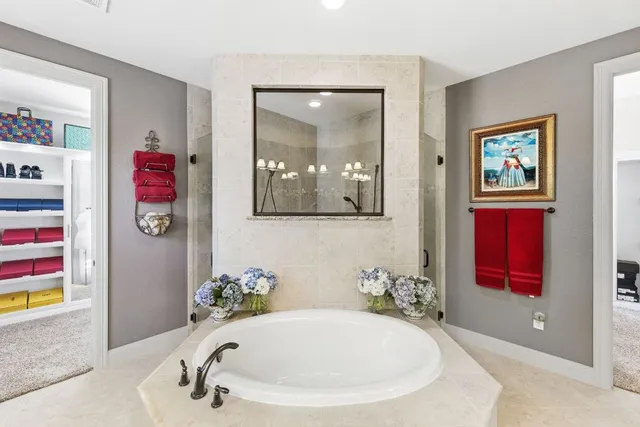 a spacious bathroom with a tub sink and mirror