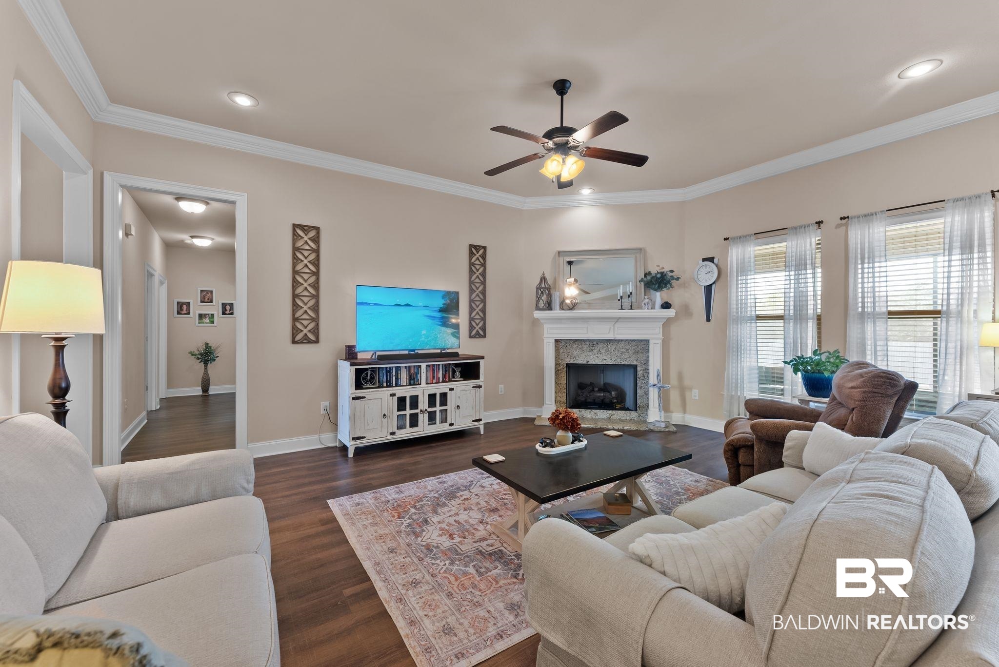 7015 Rocky Rd Loop Gulf Shores, AL 36542 - Photo 7 of 41 Living area featuring a ceiling fan, dark wood-style floors, crown molding, a fireplace, and recessed lighting
