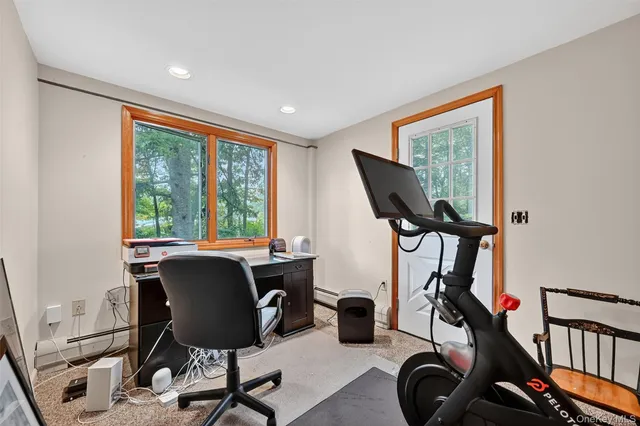 a view of a workspace with furniture and a window