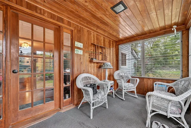 a dining room with furniture a flat screen tv and a floor to ceiling window