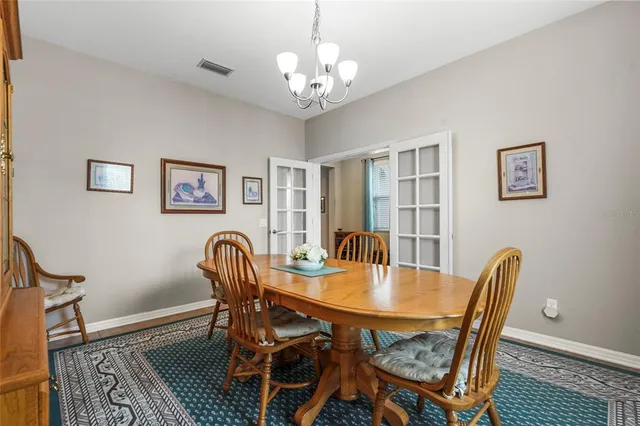 a bedroom with a bed a chandelier and a dresser