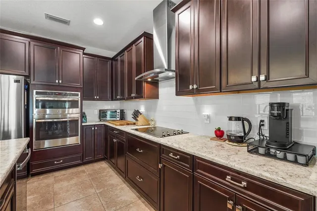 a kitchen with stainless steel appliances granite countertop a stove a sink a oven and a refrigerator