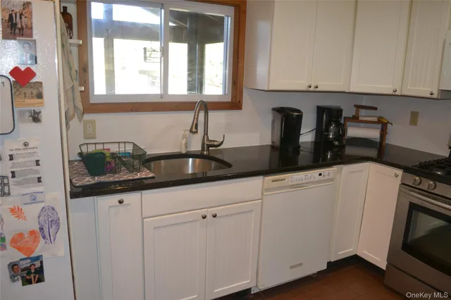 a kitchen with granite countertop white cabinets and white appliances