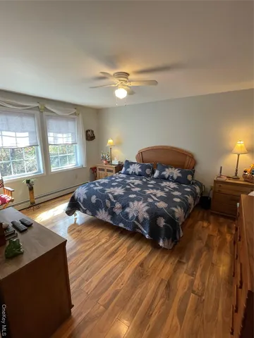 a bedroom with a bed lamps and wooden floor