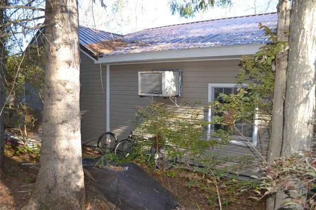 a yellow house with tree in front of it