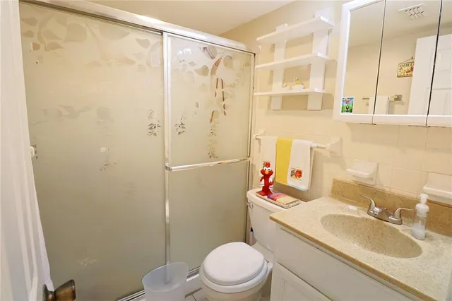 a bathroom with a sink toilet vanity and shower