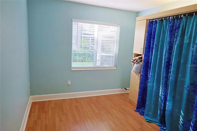 a view of a room with wooden floor and a window