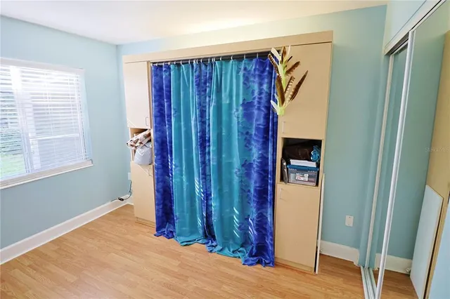 a view of a room with wooden floor and a window