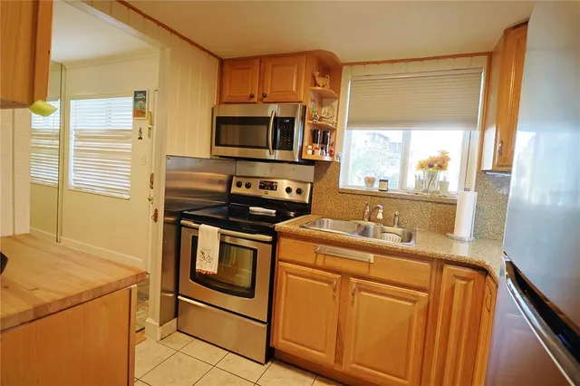 a kitchen with stainless steel appliances a stove sink and microwave