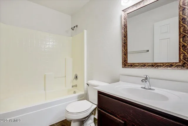 a bathroom with a granite countertop sink a toilet and a mirror