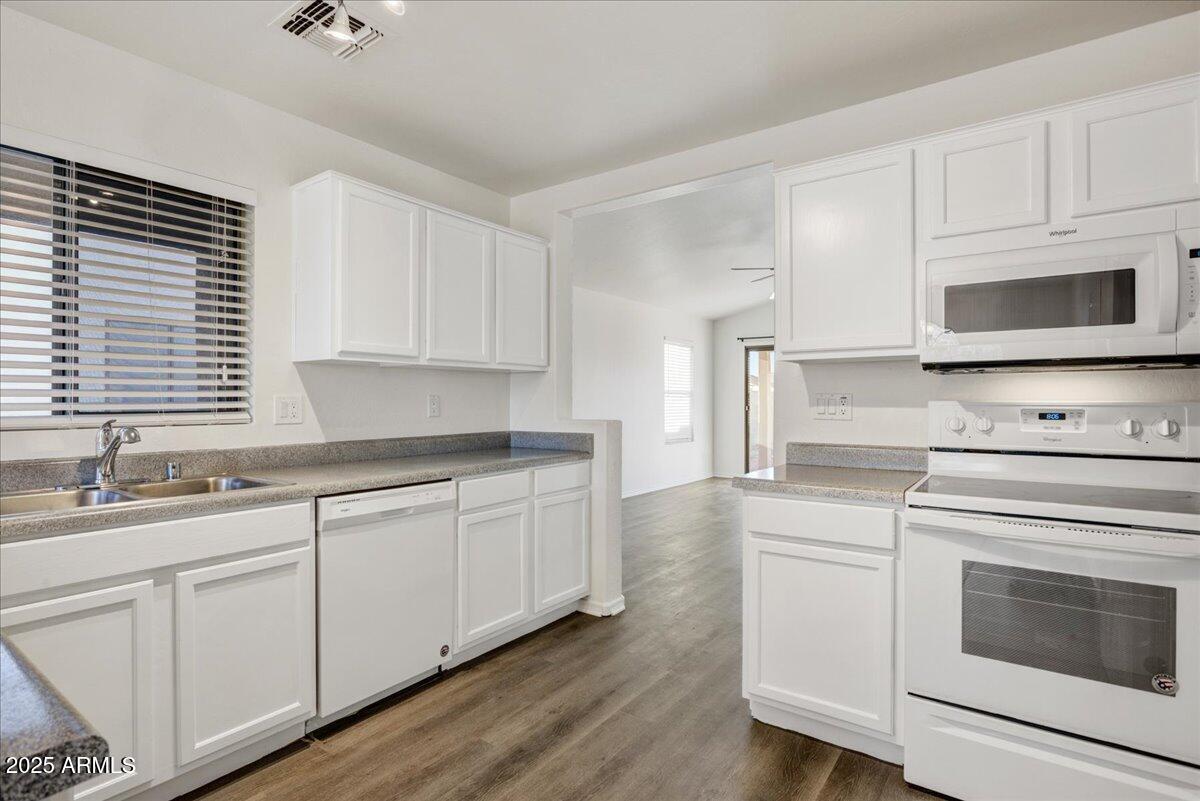 13009 West Port Royale Lane El Mirage, AZ 85335 - Photo 4 of 15 a kitchen with granite countertop white cabinets white stainless steel appliances and a sink