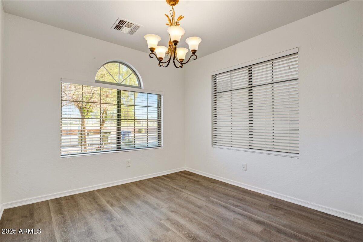 13009 West Port Royale Lane El Mirage, AZ 85335 - Photo 5 of 15 a view of an empty room with a window and wooden floor