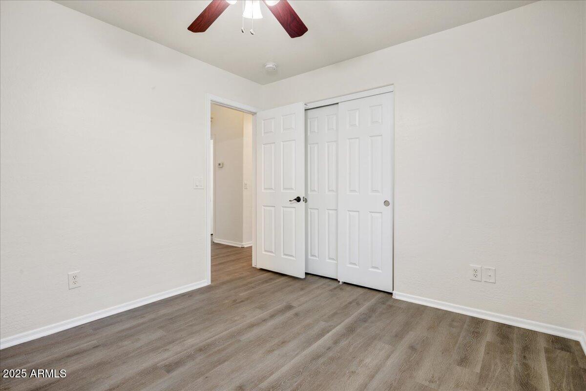 13009 West Port Royale Lane El Mirage, AZ 85335 - Photo 10 of 15 an empty room with wooden floor and windows