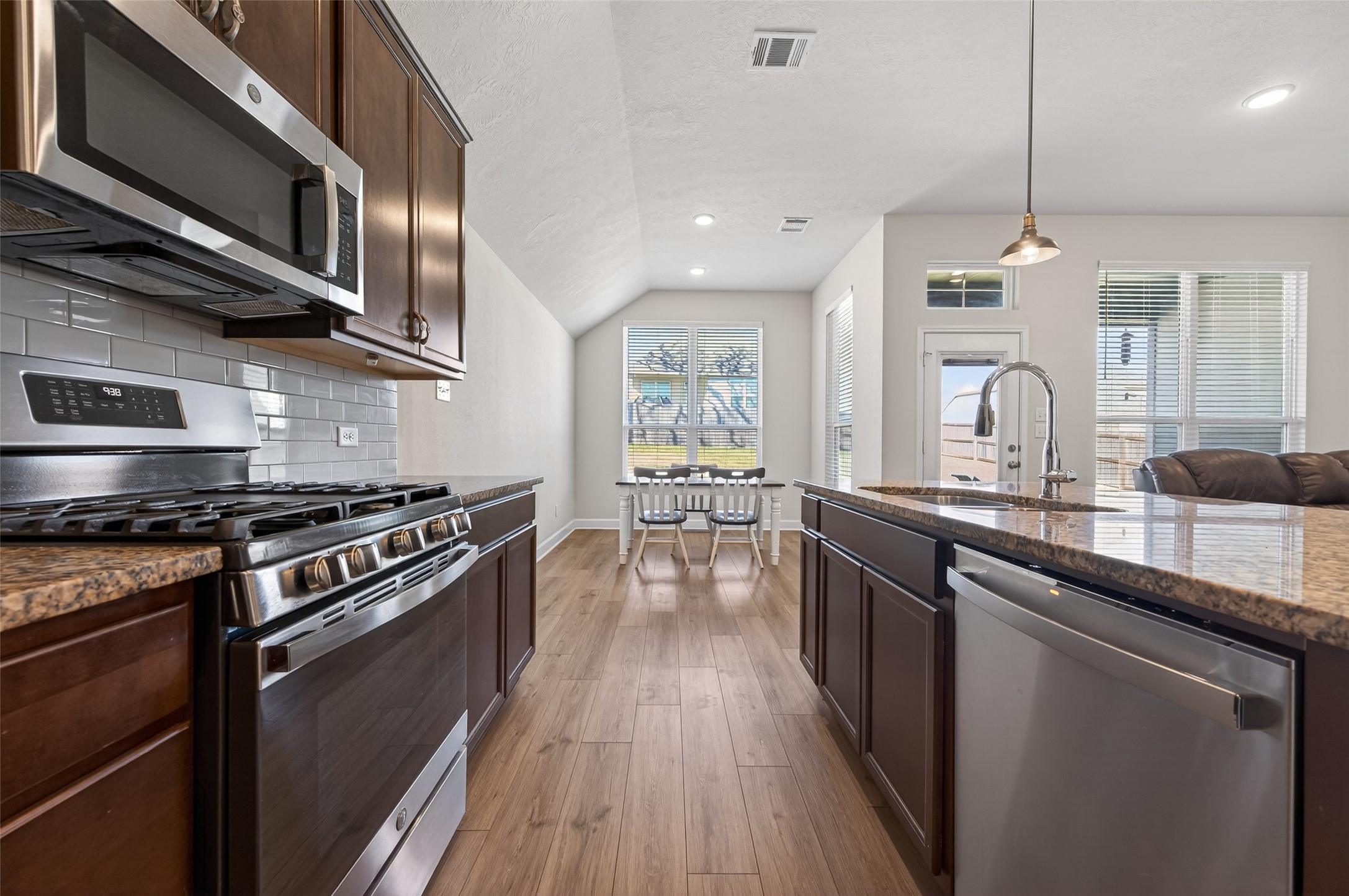 917 Farm Path Brenham, TX 77833 - Photo 13 of 43 a kitchen with stainless steel appliances granite countertop hardwood floor sink stove and granite counter top