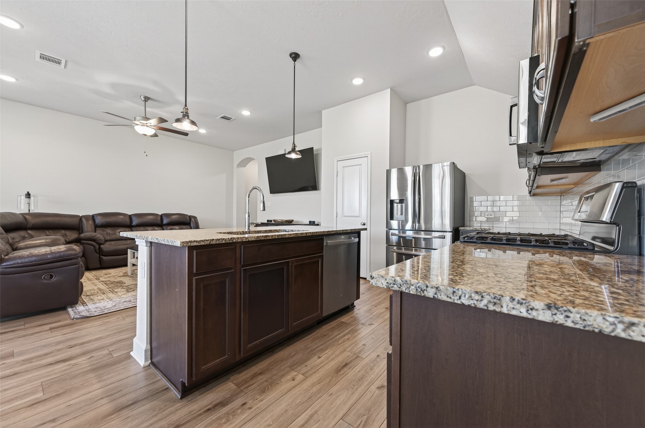 917 Farm Path Brenham, TX 77833 - Photo 17 of 43 a kitchen with stainless steel appliances granite countertop a sink a stove and a wooden floors