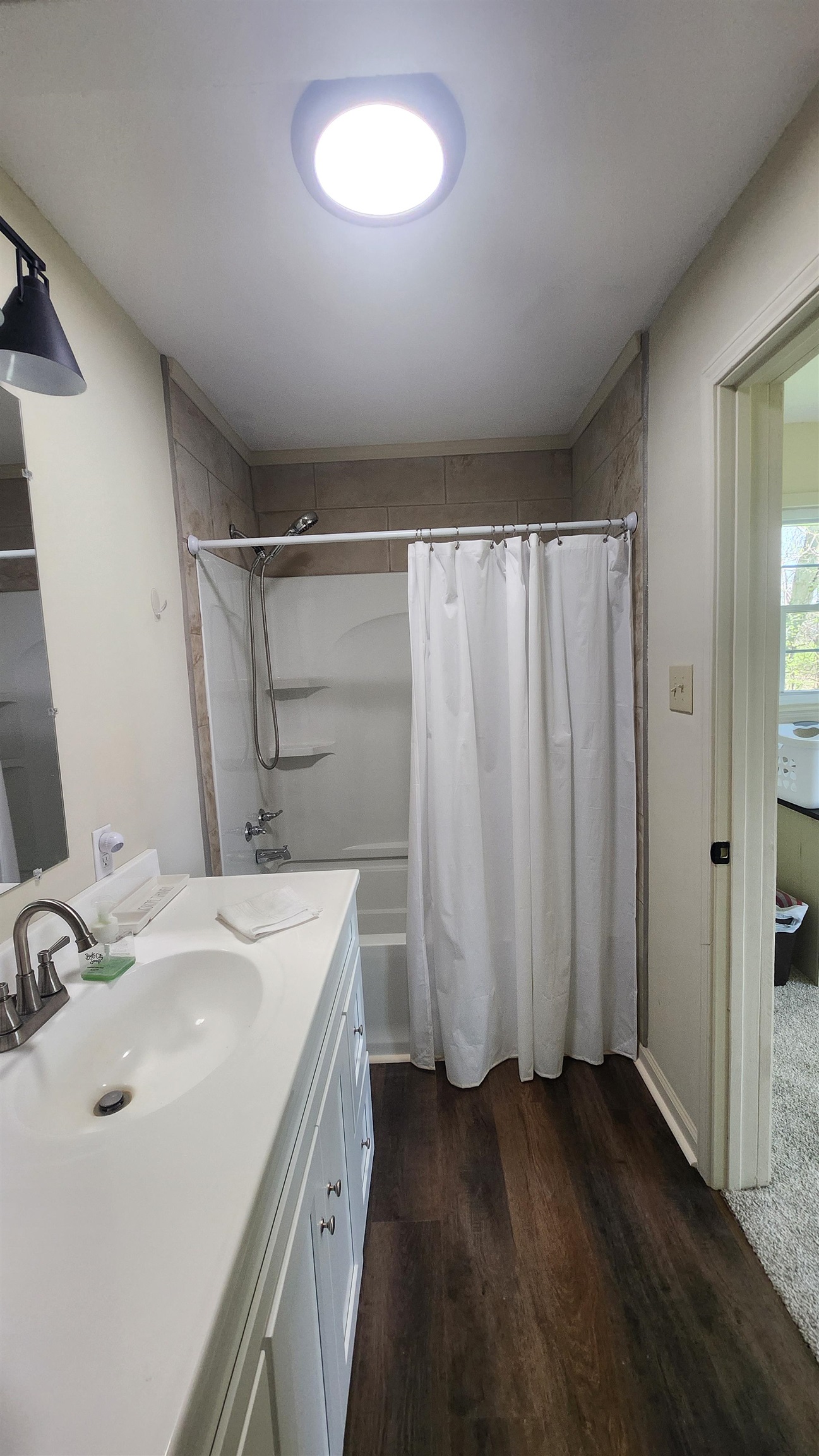 3226 19th Highway West Ripley, TN 38063 - Photo 11 of 18 Bathroom featuring vanity, shower / bath combo with shower curtain, and dark wood finished floors