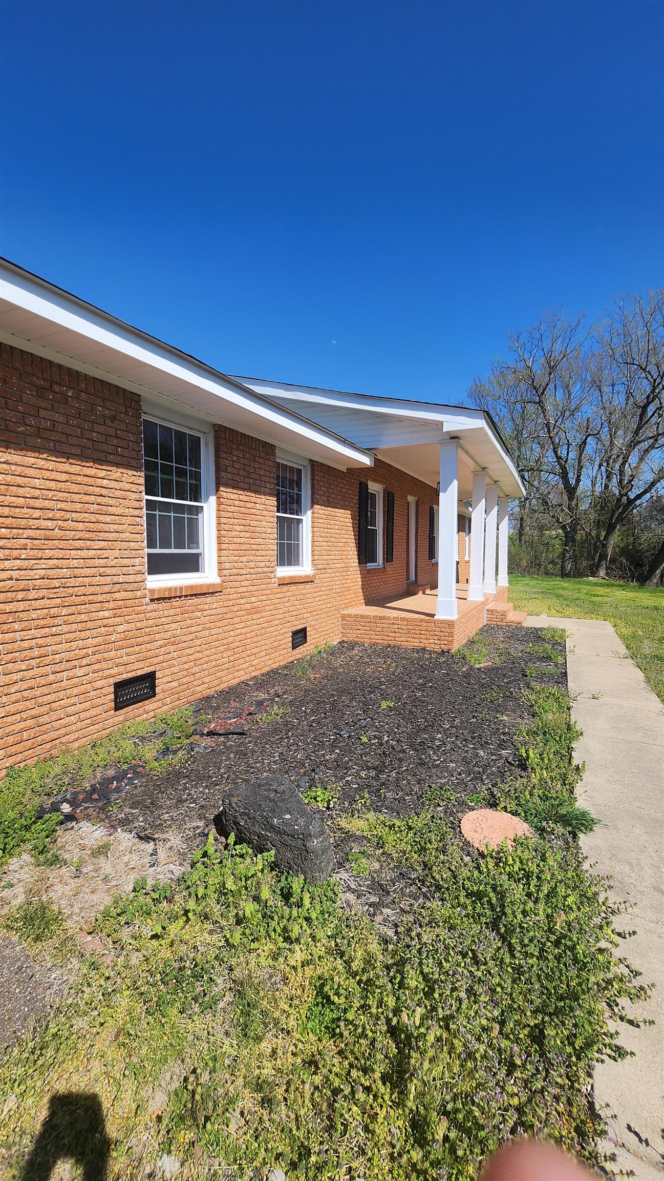 3226 19th Highway West Ripley, TN 38063 - Photo 2 of 18 View of front facade featuring crawl space, brick siding, and covered porch