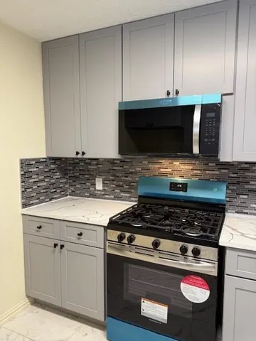 a kitchen with stainless steel appliances granite countertop a sink and a white cabinets