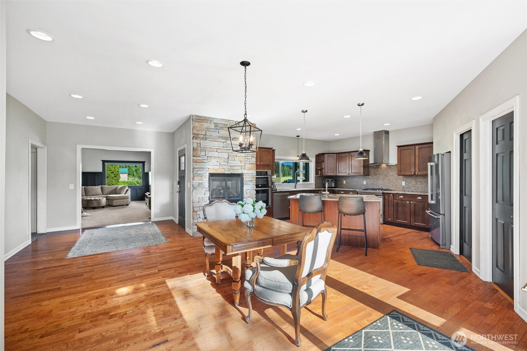 5875 Sand Road Bellingham, WA 98226 - Photo 8 of 40 a view of a dining room and livingroom with furniture wooden floor a rug a fireplace and a chandelier