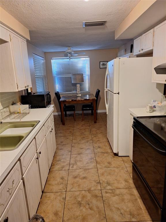 1550 Roundtree Road Holiday, FL 34690 - Photo 2 of 6 a kitchen with a sink a refrigerator and a stove