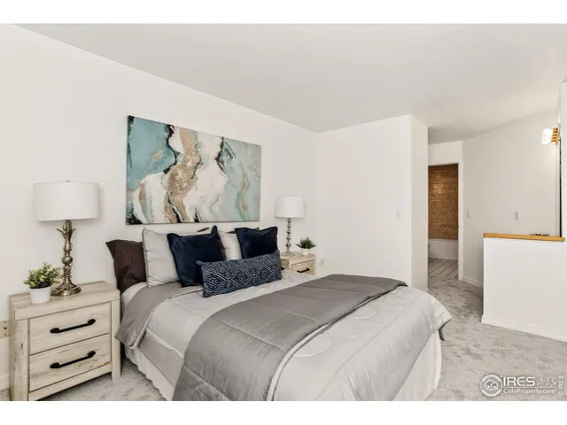 a bedroom with a bed and a painting on the wall