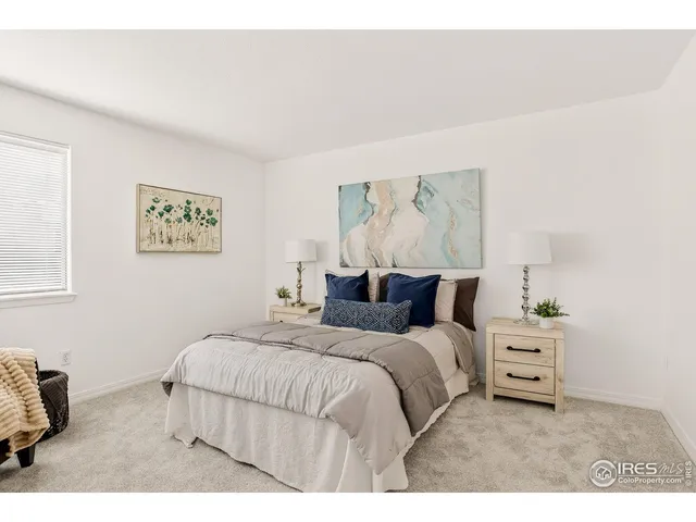 a bedroom with a bed and a painting on the wall