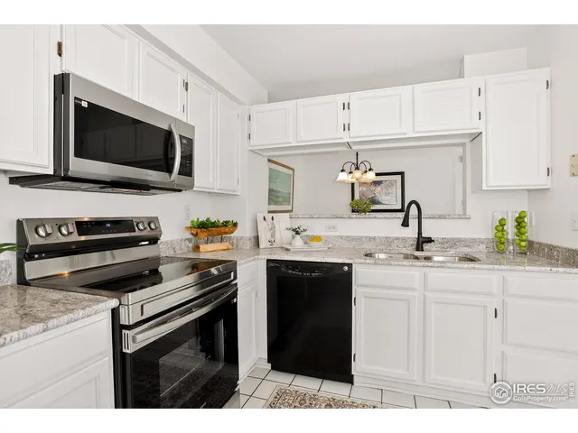 a kitchen with kitchen island white cabinets appliances and a sink